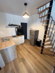 a kitchen with a spiral staircase in a room at Charmant duplex rénové à neuf in La Voulte-sur-Rhône +5 photos