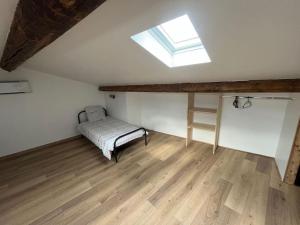 a attic room with a bed and a window at Charmant duplex rénové à neuf in La Voulte-sur-Rhône