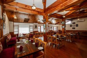 um restaurante vazio com mesas e cadeiras de madeira em JJ By Vivaan Resort em Shamshi