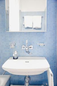 uma casa de banho com um lavatório branco e um espelho. em Amazing studio in the city centre (Art 12) em Zürich