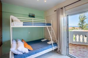 a bunk bed in a room with a window at Betty seaside villa in Pefkochori