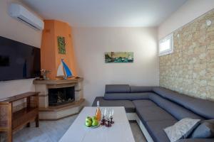 a living room with a blue couch and a fireplace at Betty seaside villa in Pefkochori