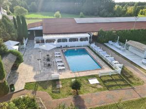 an overhead view of a pool with tables and chairs at Hotel Kurpia Arte in Nowogród