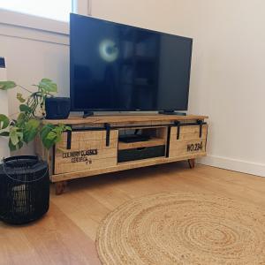 a flat screen tv sitting on top of a wooden entertainment center at Curota A in Ribeira