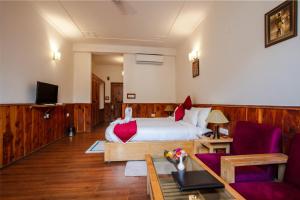 ein Hotelzimmer mit einem Bett und einem Tisch in der Unterkunft JJ By Vivaan Resort in Shamshi