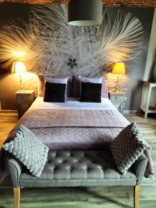 um quarto com uma cama grande e um edredão roxo em Le Charm'en Gîte em Tournai