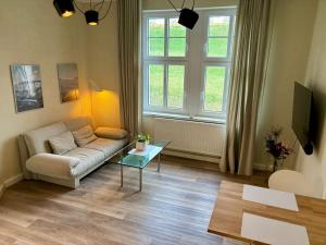 a living room with a couch and a table at Gemütliches Refugium am Bahnhof - Perfekt zum erkunden der Sächsischen Schweiz in Sebnitz