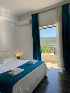 1 dormitorio con cama y ventana grande en Villa August Ksamil, en Ksamil