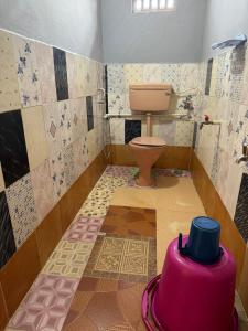 baño con aseo y azulejos en el suelo en KENSONS BUDGETSTAY NON AC FREE WIFI and PARKING, en Mangalore