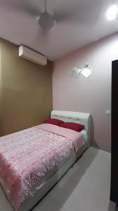 sypialnia z łóżkiem z różową pościelą i wentylatorem w obiekcie UMMUL MOTEL w mieście Arau