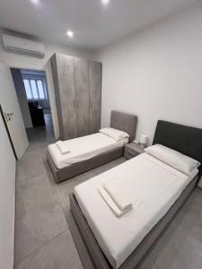 een kamer met 2 bedden in een kamer bij Appartamento The Twins in Asti