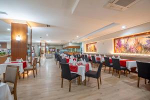 une salle à manger avec des tables et des chaises blanches dans l'établissement Side Breeze Hotel, à Antalya