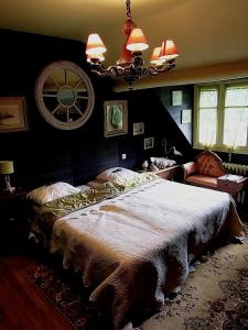 Un dormitorio con una cama grande y una lámpara de araña. en Ferme de la Dorvallière en Cavagnac