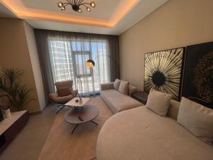 a living room with a couch and a table at 2 Luxury bedroom Apartment In Amwaj Island in Qalānī