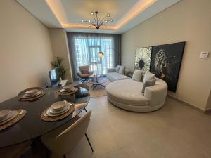 a living room with a couch and a table at 2 Luxury bedroom Apartment In Amwaj Island in Qalānī