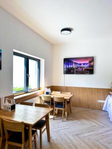 布雷茲諾的住宿－Penzion Mlyn - Bystra，一间设有桌子的用餐室和墙上的电视