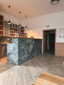 a kitchen with a marble counter top and wooden floors at Penzion Mlyn - Bystra in Brezno