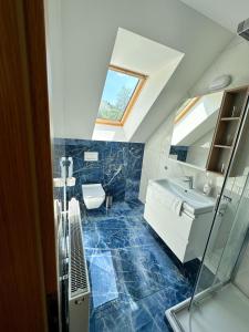 a bathroom with a sink and a toilet and a mirror at Penzion Mlyn - Bystra in Brezno