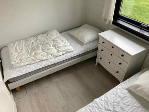 Dormitorio pequeño con cama y vestidor en Cozy Cottage Close To The Beach, en Bogense