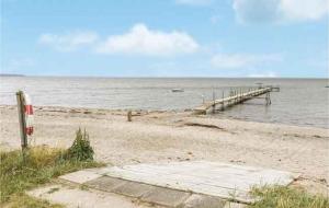 a beach with a pier and the ocean at Cozy Cottage Close To The Beach, in Bogense