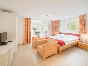ein Schlafzimmer mit einem Bett, einem Sofa und Fenstern in der Unterkunft Haus Powder Snow in Zermatt