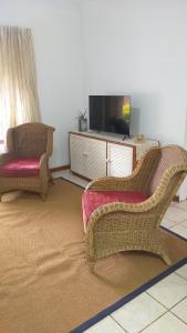 a living room with two chairs and a television at My stay away from home in Mtunzini