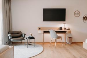 a living room with a desk and two chairs at Hotel Nesslerhof in Grossarl