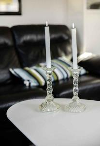 two glass candle holders on a table with a couch at Lovely Holiday Home Near Hasmark Beach in Otterup