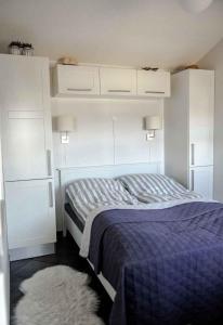 a bedroom with a bed and white cabinets and a rug at Lovely Holiday Home Near Hasmark Beach in Otterup