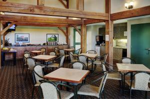 a restaurant with tables and chairs and a counter at Lakeview Inns & Suites - Okotoks in Okotoks