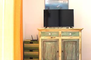 telewizor na drewnianej szafce z komodą w obiekcie Casa Goletta soggiorno per 4 a 2 minuti dalla spiaggia w mieście Cala Gonone