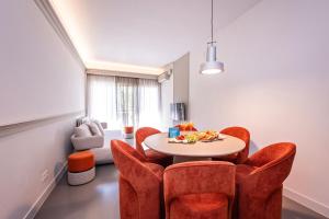 sala de estar con mesa y sillas de color naranja en Sweet Inn - Gaudi Avenue, en Barcelona