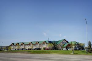 a large building with a green roof on a street at Lakeview Inns & Suites - Okotoks in Okotoks
