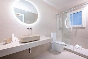 a bathroom with a sink and a toilet and a mirror at Sweet Inn - Gaudi Avenue in Barcelona