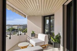a balcony with white furniture and a view of the city at luxurious penthouse of Cannes in Cannes