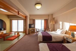 a hotel room with two beds and a television at Merveille Arima in Kobe