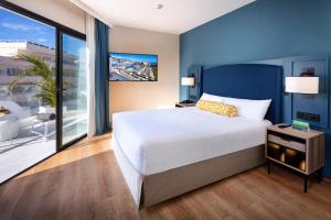 um quarto com uma cama grande e uma varanda em Princess Inspire Tenerife - Adults Only em Adeje