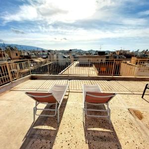 due sedie sedute sopra un tetto di Acropolis View Dream ad Atene