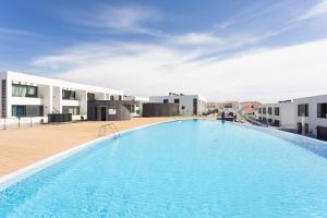 une grande piscine au milieu d'un bâtiment dans l'établissement Maruxía Beach and Pool apartemnt, à Abades