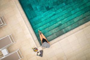 a woman is laying next to a swimming pool at Princess Inspire Tenerife - Adults Only in Adeje