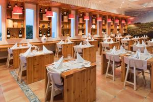 um restaurante com mesas de madeira e cadeiras brancas em Club Jandía Princess em Playa Jandia mais 54 fotografias