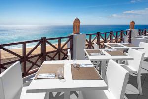 uma fila de mesas numa varanda com o oceano em Club Jandía Princess em Playa Jandia mais 41 fotografias