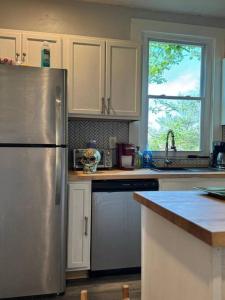eine Küche mit einem Kühlschrank aus Edelstahl und einem Fenster in der Unterkunft Wellness Oasis Near Downtown Pittsburgh in Pittsburgh