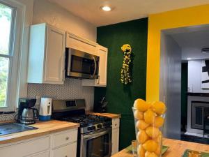 eine Küche mit einer grünen und gelben Wand in der Unterkunft Wellness Oasis Near Downtown Pittsburgh in Pittsburgh