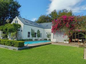 a house with a swimming pool and a yard at Alzare Villa in Greyton