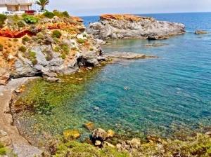 蓋博德帕洛斯的住宿－Cabo de palos subida al faro，一片拥有岩石和水的海滩和一座房子