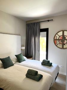 a bedroom with two beds with green pillows on them at BONAVISTA PLATJA BEGUR in Begur