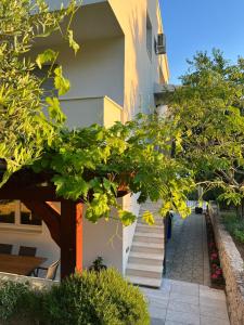 schody prowadzące do budynku z zielonymi drzewami w obiekcie Apartments Curnić w mieście Jesenice