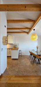 a kitchen and dining room with wooden ceilings and a table at Apartment Bluemare B6 with Shared Pool in Ližnjan +20 photos