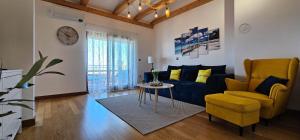 a living room with a couch and a chair and a table at Apartment Bluemare B6 with Shared Pool in Ližnjan
